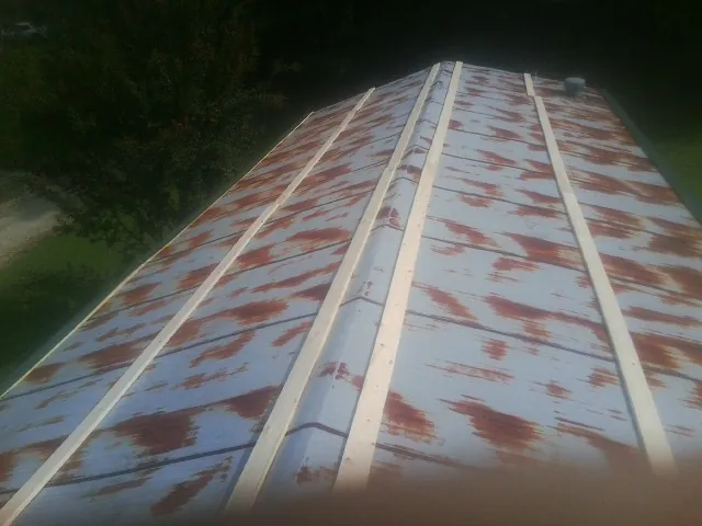 Rusted metal roof panels with new wood purlins before replacement — Storm Damage Roof Repair in Preble by Roofing Brothers